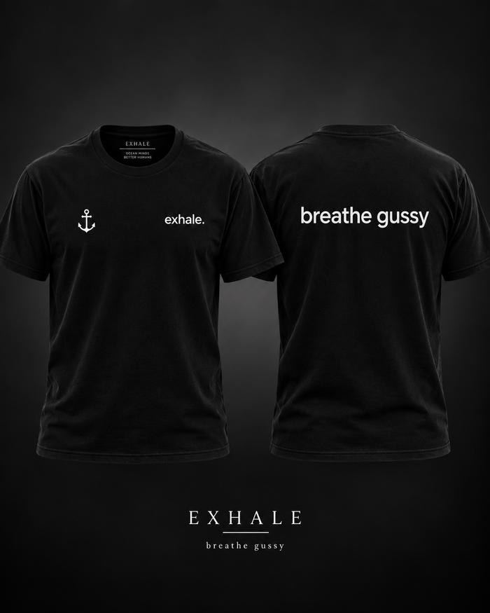 Exhale breathe gussy black tee mockup, larger white lowercase breathe gussy text on the back, small white exhale and anchor on the front.